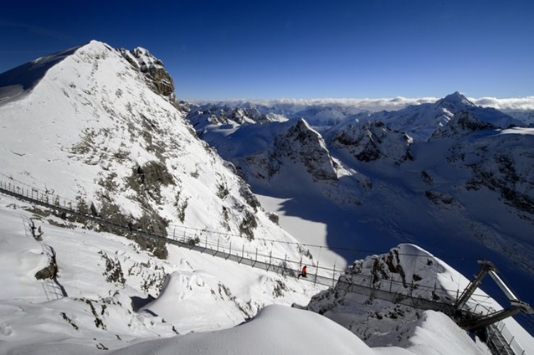 A worker walks on the highest suspension bridge in Europe on December 1, 2012 in the Titlis mountain above Engelberg, Central Switzerland. To mark the 100th anniversary of the Titlis cableways, a 100-meter-long suspension bridge is being built at more than 3041 meters above the sea level and will be the highest suspension bridge in Europe. The bridge is expected to be opened on December 7, 2012. AFP PHOTO / FABRICE COFFRINI (Photo credit should read FABRICE COFFRINI/AFP/Getty Images)