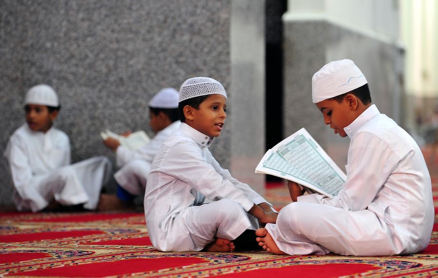 Saudi boys recite verses from the Koran, Islam's holy book, at a mosque in the Red Sea city of Jeddah on August 27, 2009. The rising number of swine flu cases and deaths across the Middle East has cast a cloud over the Muslim fasting month of Ramadan, with a plunge in the number of people going on pilgrimage to Mecca. AFP PHOTO/OMAR SALEM